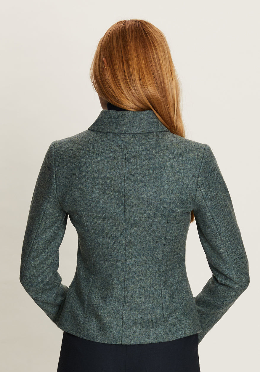 Teal jacket worn by a person on a plain background