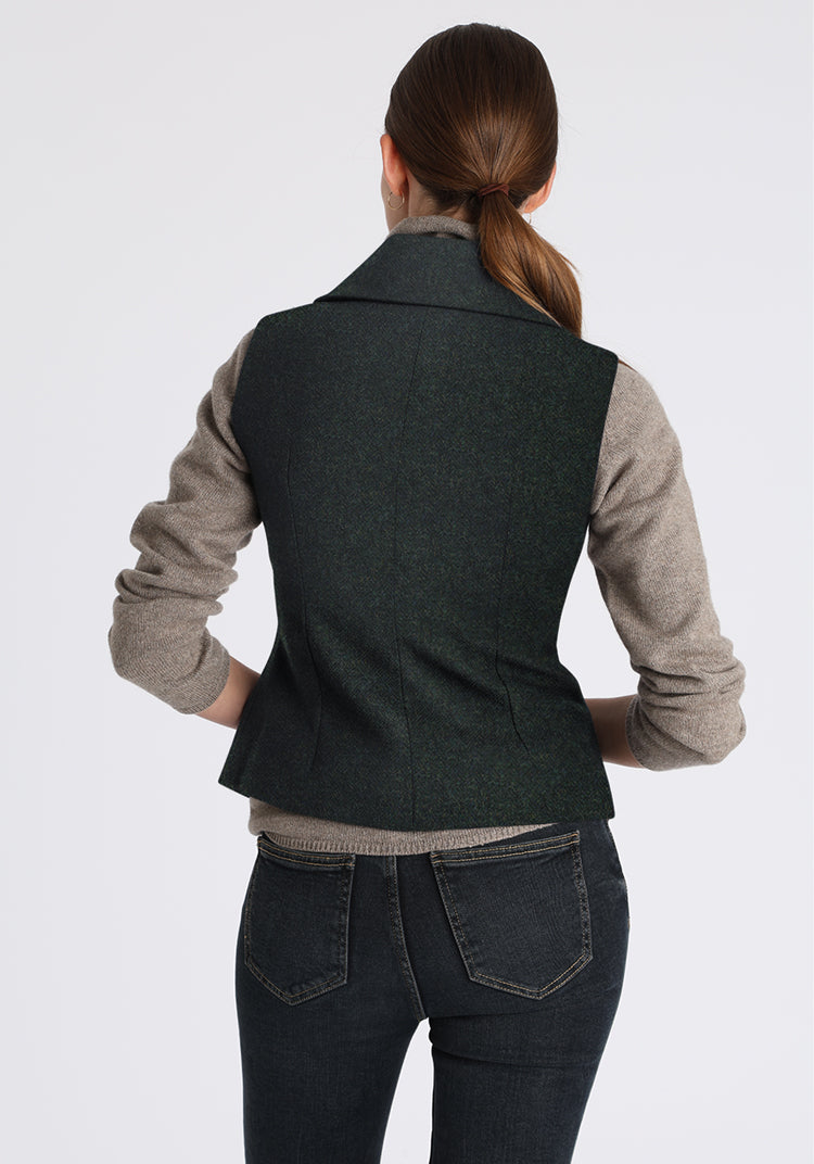 Person wearing a green waistcoat over a gray shirt on a white background
