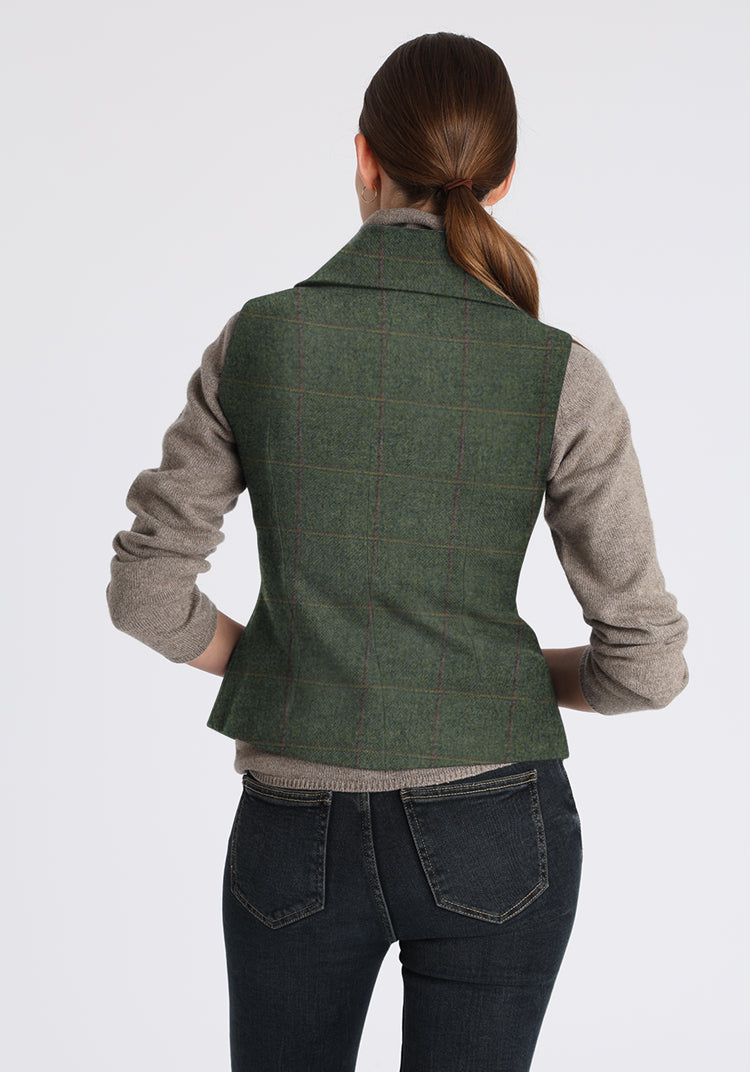 Person wearing a gray plaid waistcoat over a gray shirt with a white background