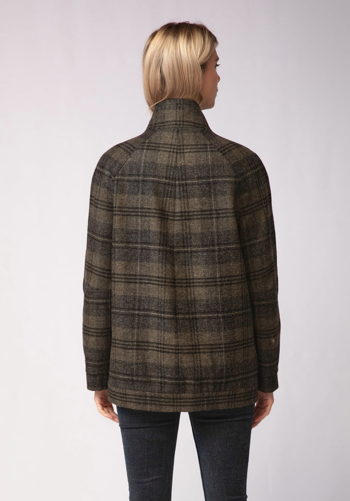 Person wearing a green and grey plaid jacket on a white background