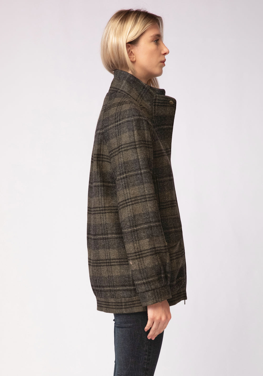 Person wearing a green and grey plaid jacket on a white background