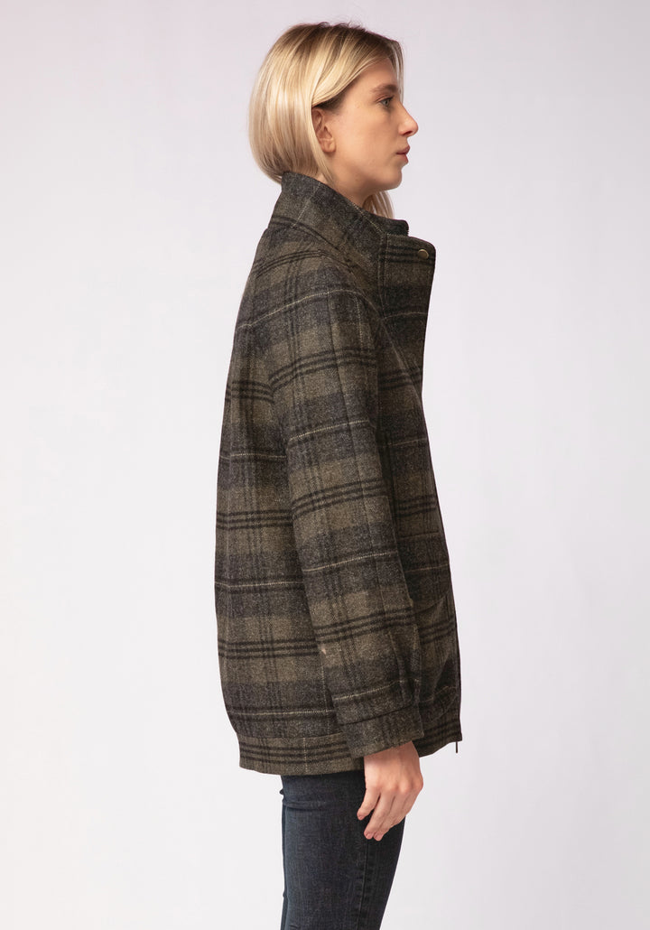 Person wearing a green and grey plaid jacket on a white background