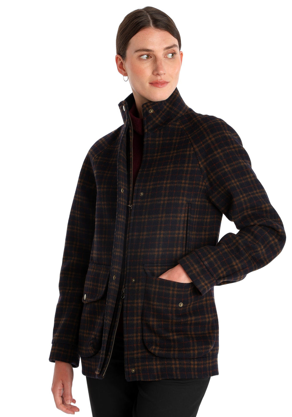 Model wearing the Andrea jacket in navy and rust thick merino wool, a heritage-inspired style with relaxed raglan sleeves, a high neck, and generous pockets, finished with antique brass hardware.