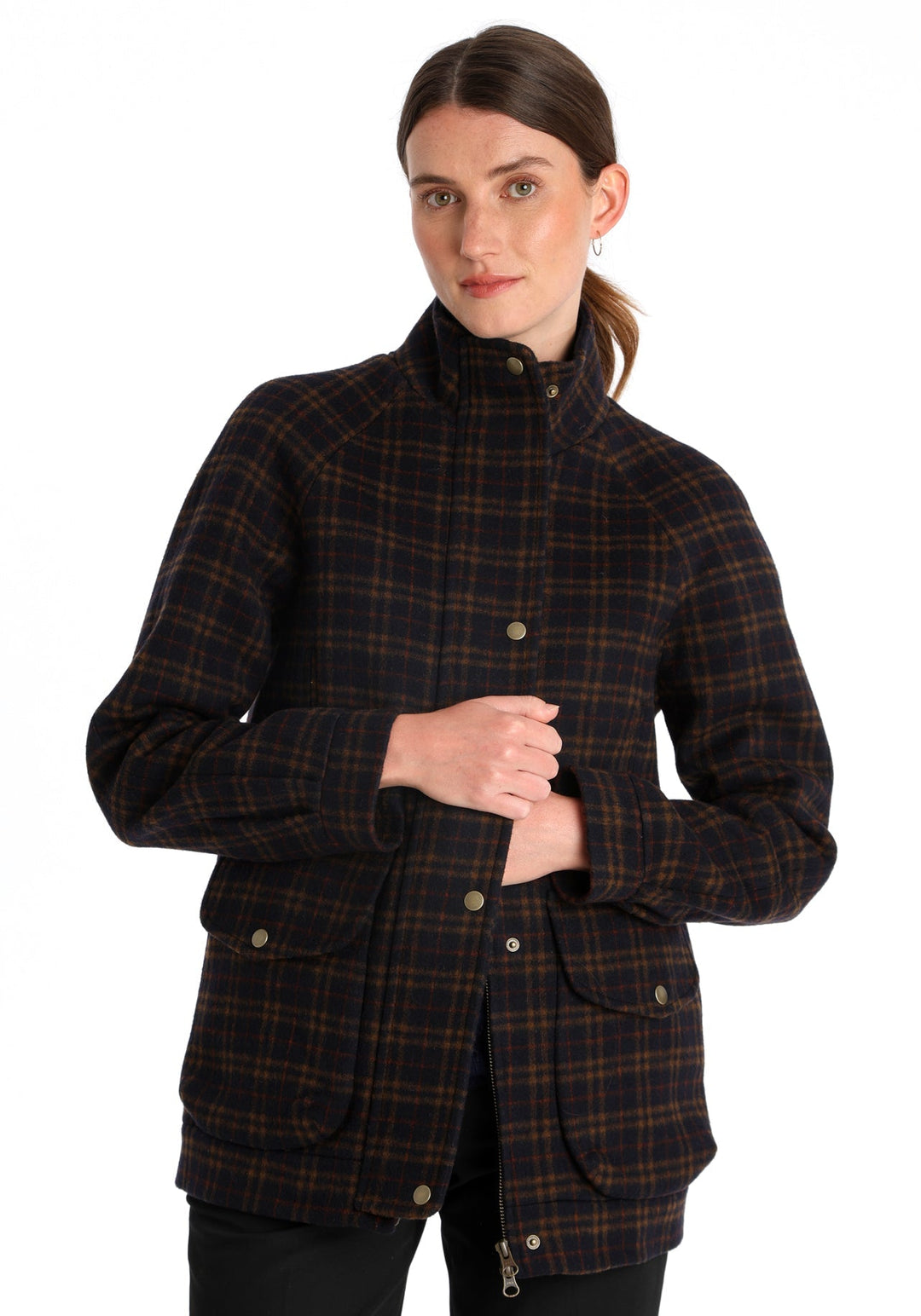 Model wearing the Andrea jacket in navy and rust thick merino wool, a heritage-inspired style with relaxed raglan sleeves, a high neck, and generous pockets, finished with antique brass hardware.