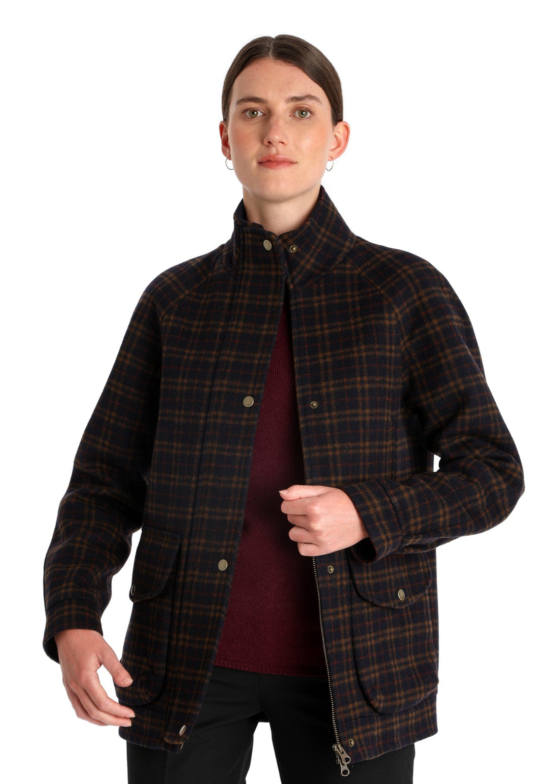 Model wearing the Andrea jacket in navy and rust thick merino wool, a heritage-inspired style with relaxed raglan sleeves, a high neck, and generous pockets, finished with antique brass hardware.