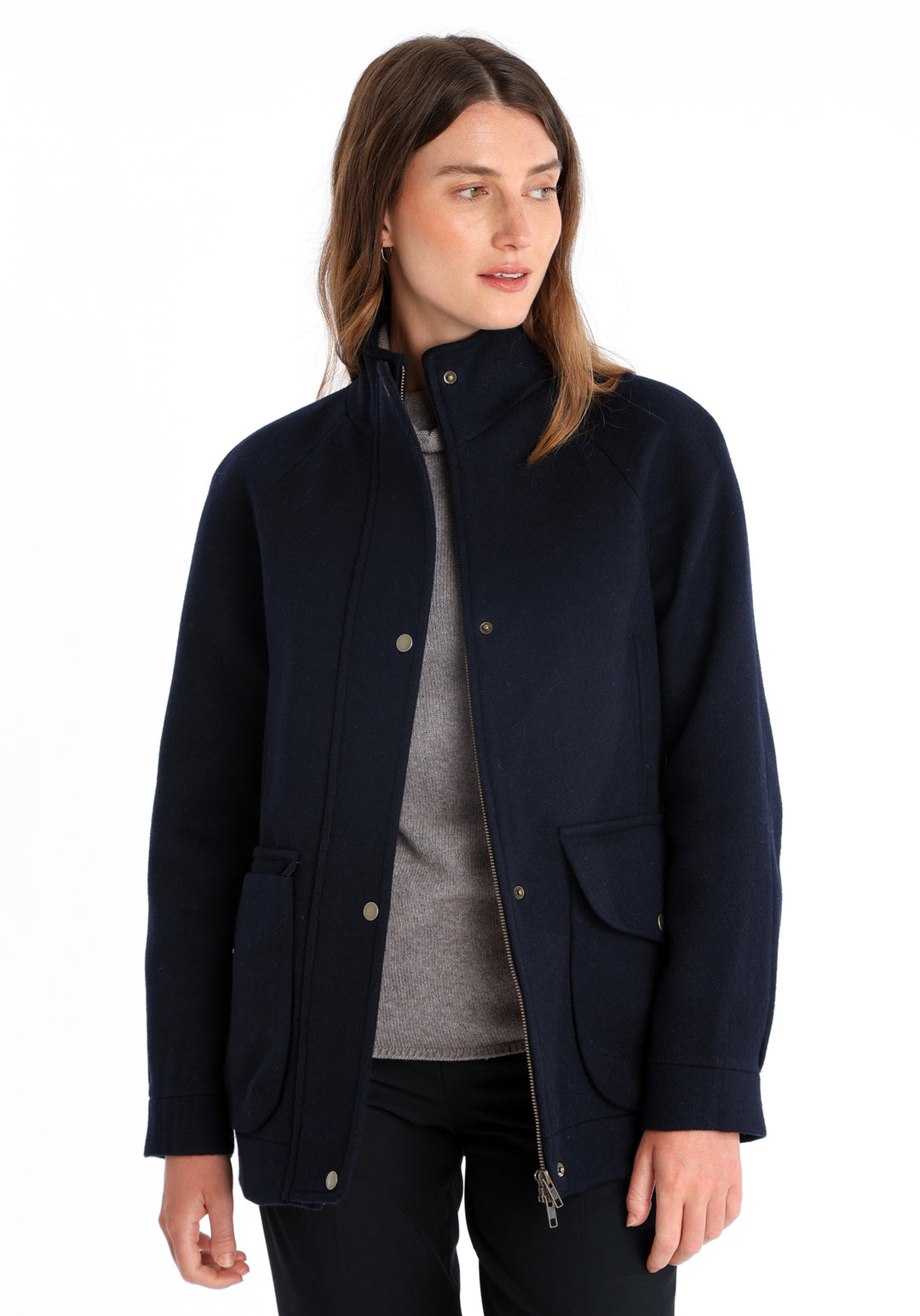Model wearing the Andrea jacket in navy and rust thick merino wool, a heritage-inspired style with relaxed raglan sleeves, a high neck, and generous pockets, finished with antique brass hardware.