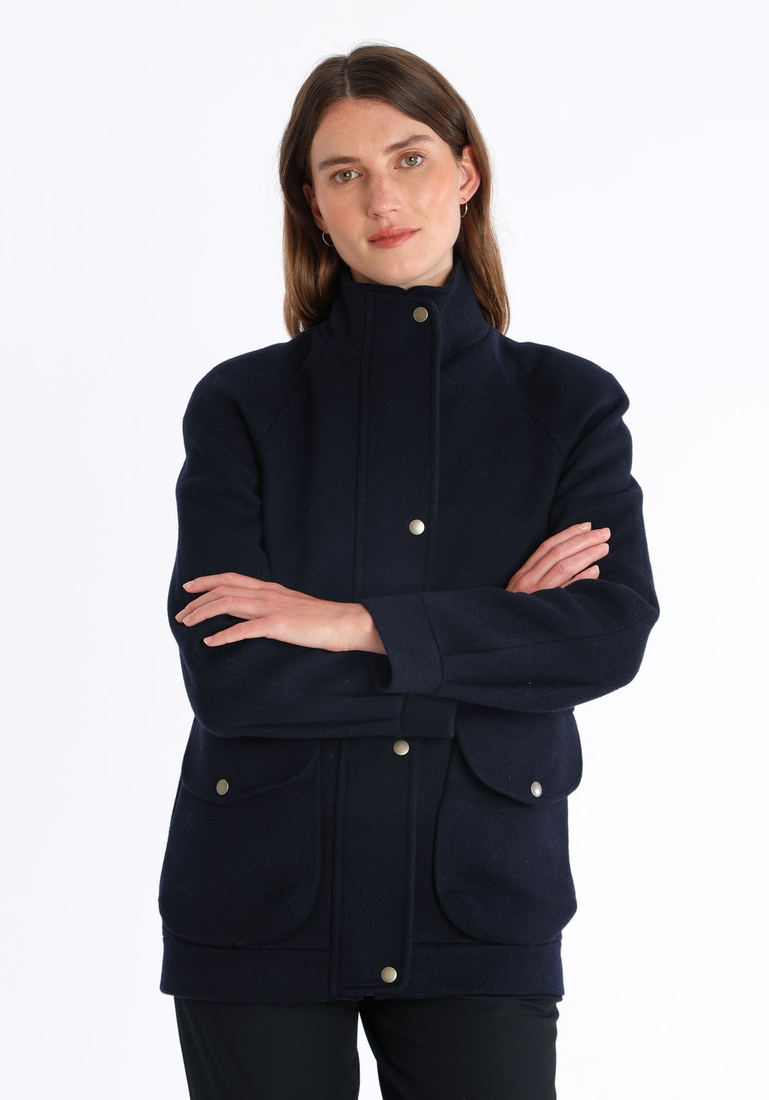 Model wearing the Andrea jacket in navy and rust thick merino wool, a heritage-inspired style with relaxed raglan sleeves, a high neck, and generous pockets, finished with antique brass hardware.