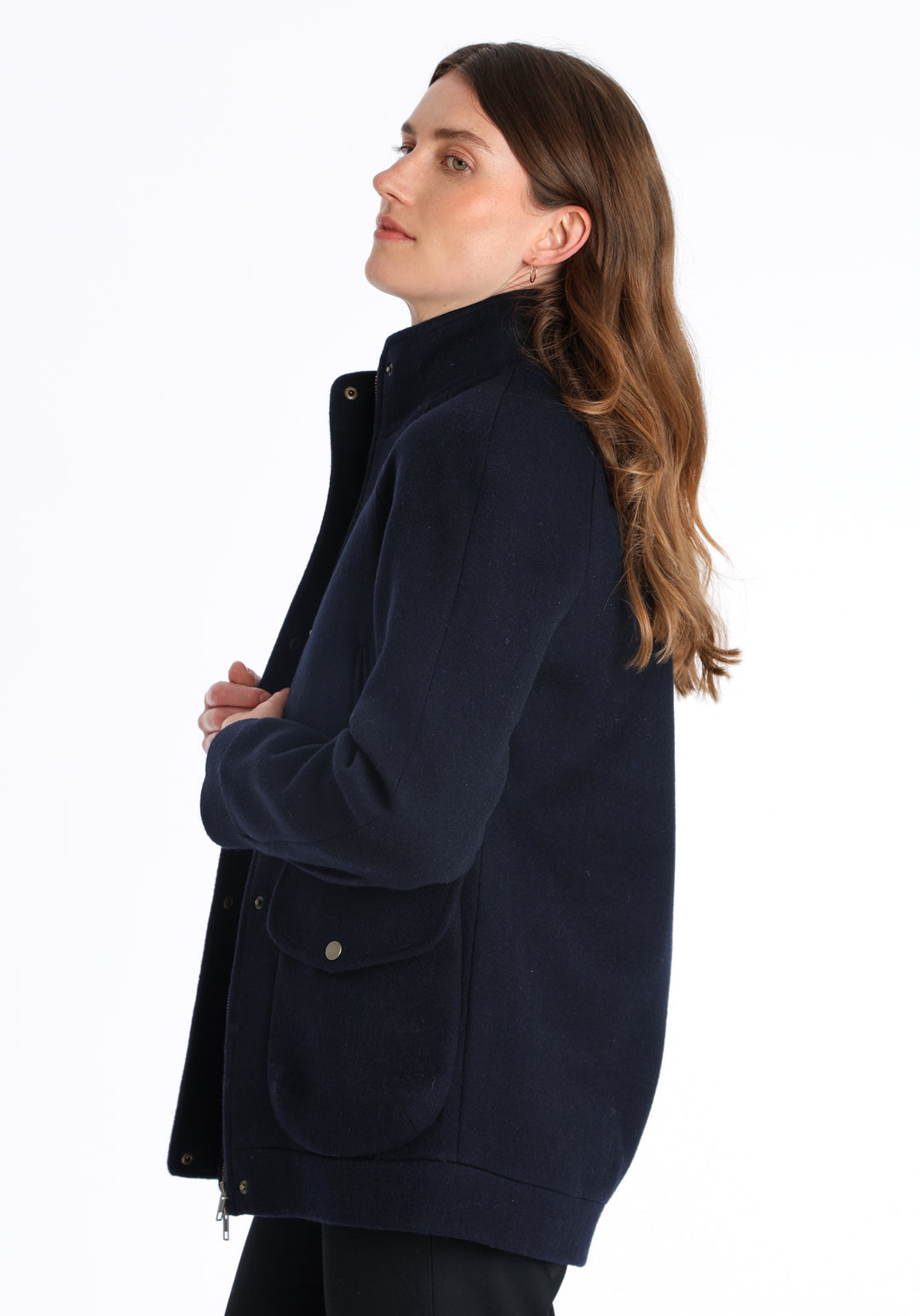 Model wearing the Andrea jacket in navy and rust thick merino wool, a heritage-inspired style with relaxed raglan sleeves, a high neck, and generous pockets, finished with antique brass hardware.