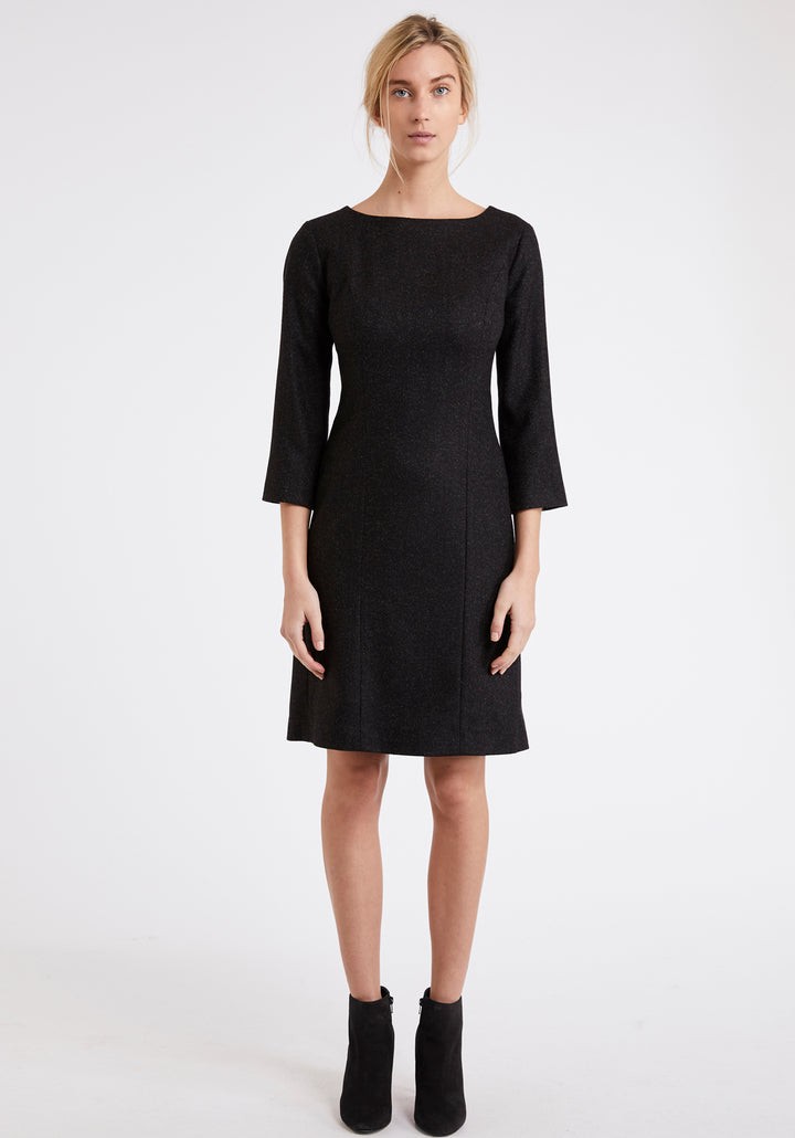 Model wearing the Ascot dress in black wool crepe. A simple shift dress with a back vent and three quarter length sleeves.