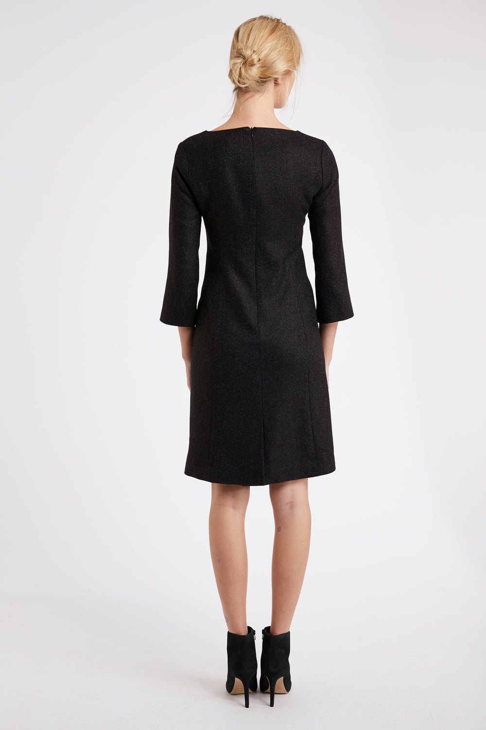 Model wearing the Ascot dress in black wool crepe. A simple shift dress with a back vent and three quarter length sleeves.