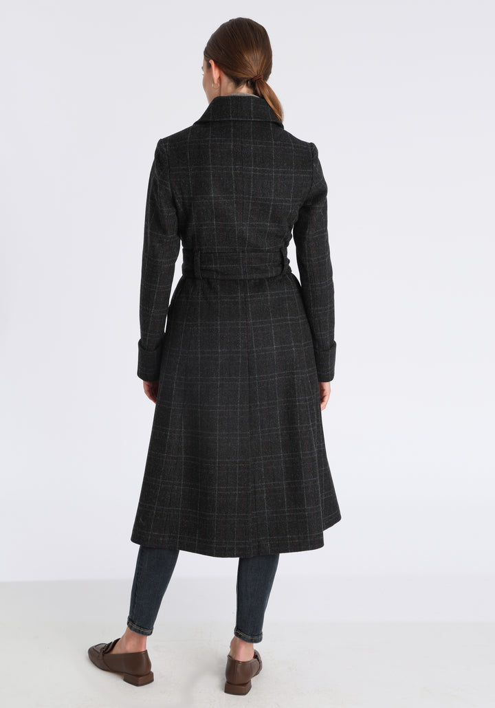 Model wearing the Belted coat in black with faint overcheck, a long tailored style with a matching belt, turn-back cuffs, and a deep back vent for ease of movement.
