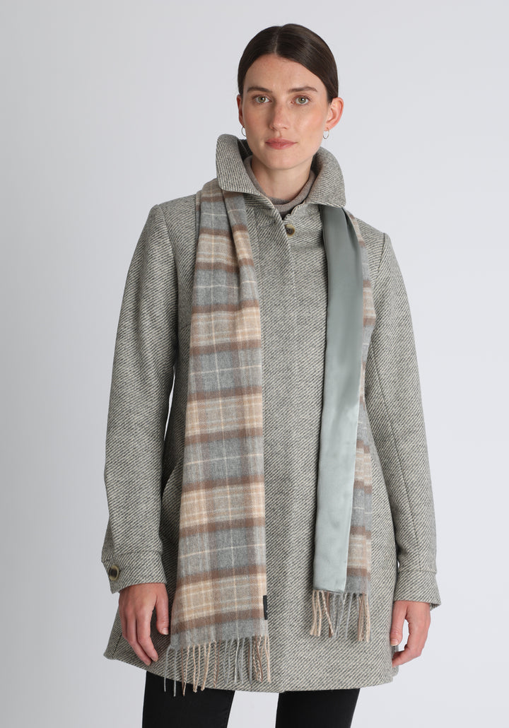 Model wearing the natural check cashmere scarf backed with silver blue silk, over the Cape coat in grey angle stripe.