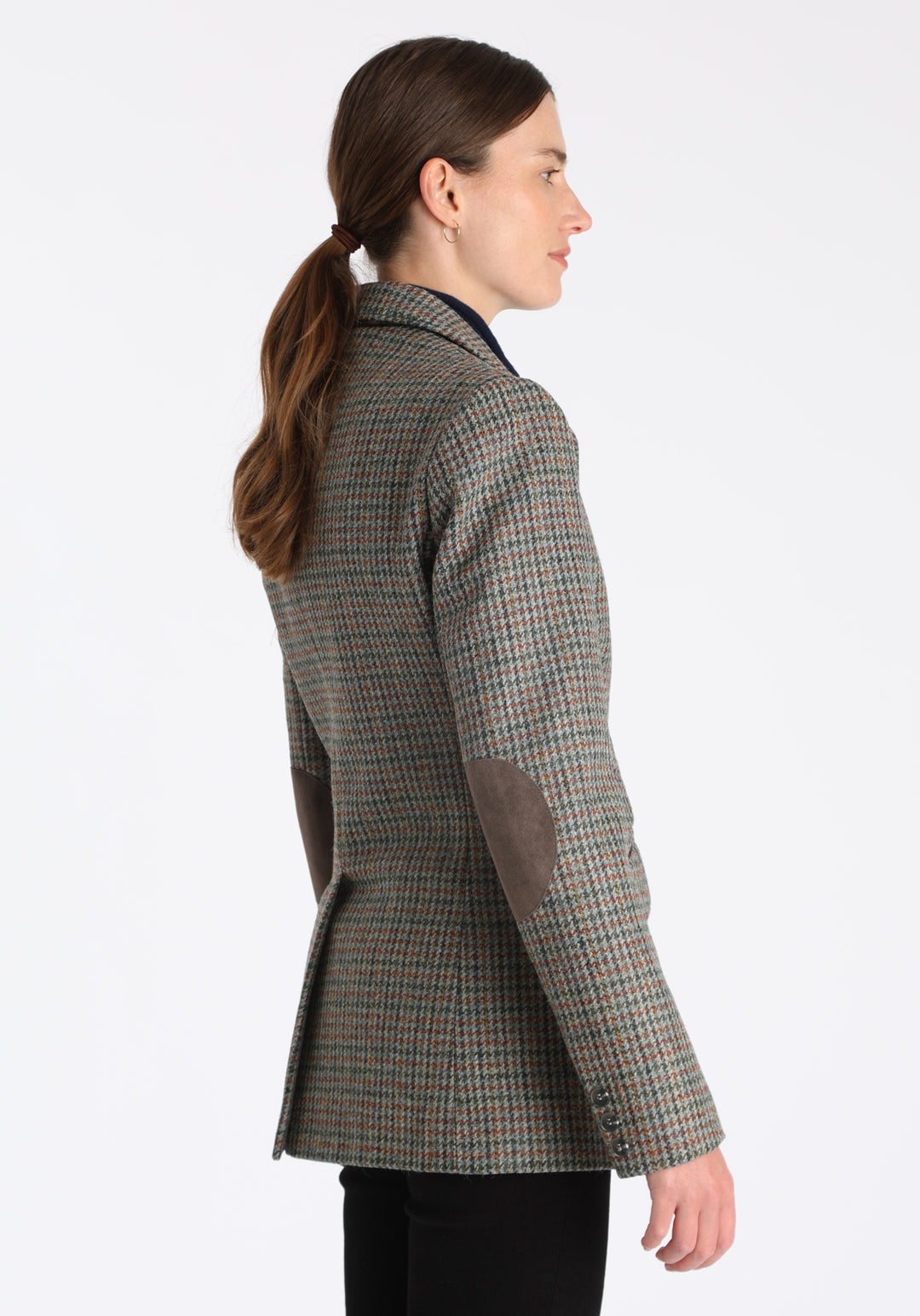 Model wearing the Cass jacket in autumnal cinder dogtooth wool check with silk velvet trim, a longline, relaxed boyfriend-style jacket with welt pockets, and buttoned collar tab inspired by equestrian tailoring.
