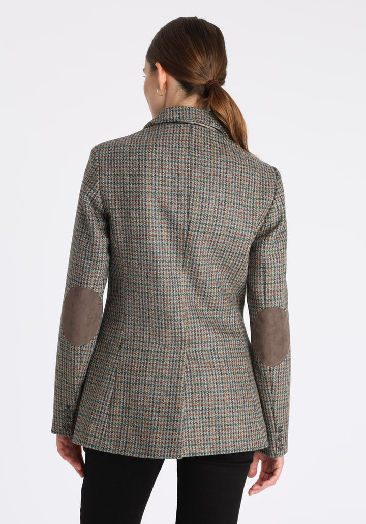 Model wearing the Cass jacket in autumnal cinder dogtooth wool check with silk velvet trim, a longline, relaxed boyfriend-style jacket with welt pockets, and buttoned collar tab inspired by equestrian tailoring.