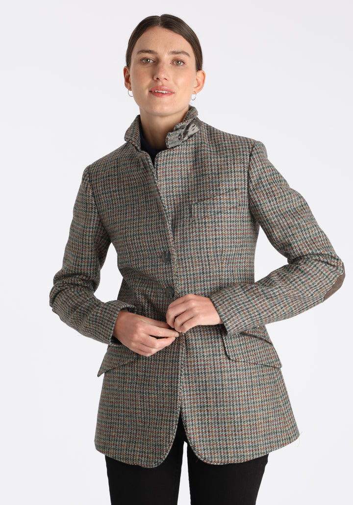 Model wearing the Cass jacket in autumnal cinder dogtooth wool check with silk velvet trim, a longline, relaxed boyfriend-style jacket with welt pockets, and buttoned collar tab inspired by equestrian tailoring.
