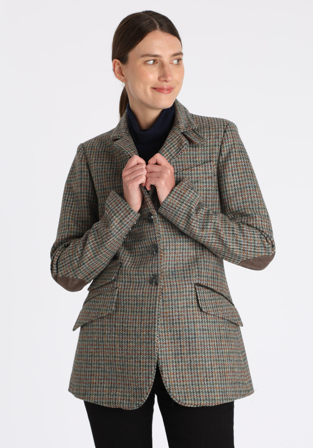 Model wearing the Cass jacket in autumnal cinder dogtooth wool check with silk velvet trim, a longline, relaxed boyfriend-style jacket with welt pockets, and buttoned collar tab inspired by equestrian tailoring.