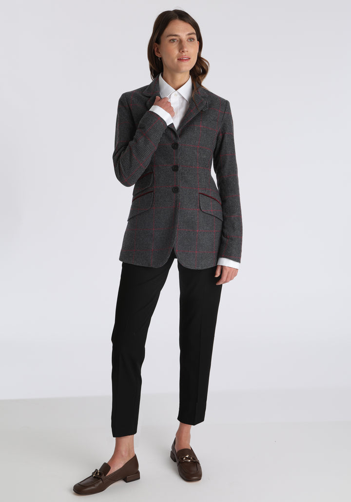 Model wearing the Cass jacket in grey a fuschia winterberry wool cashmere check with cotton velvet trim, a longline, relaxed boyfriend-style jacket with welt pockets, and buttoned collar tab inspired by equestrian tailoring.