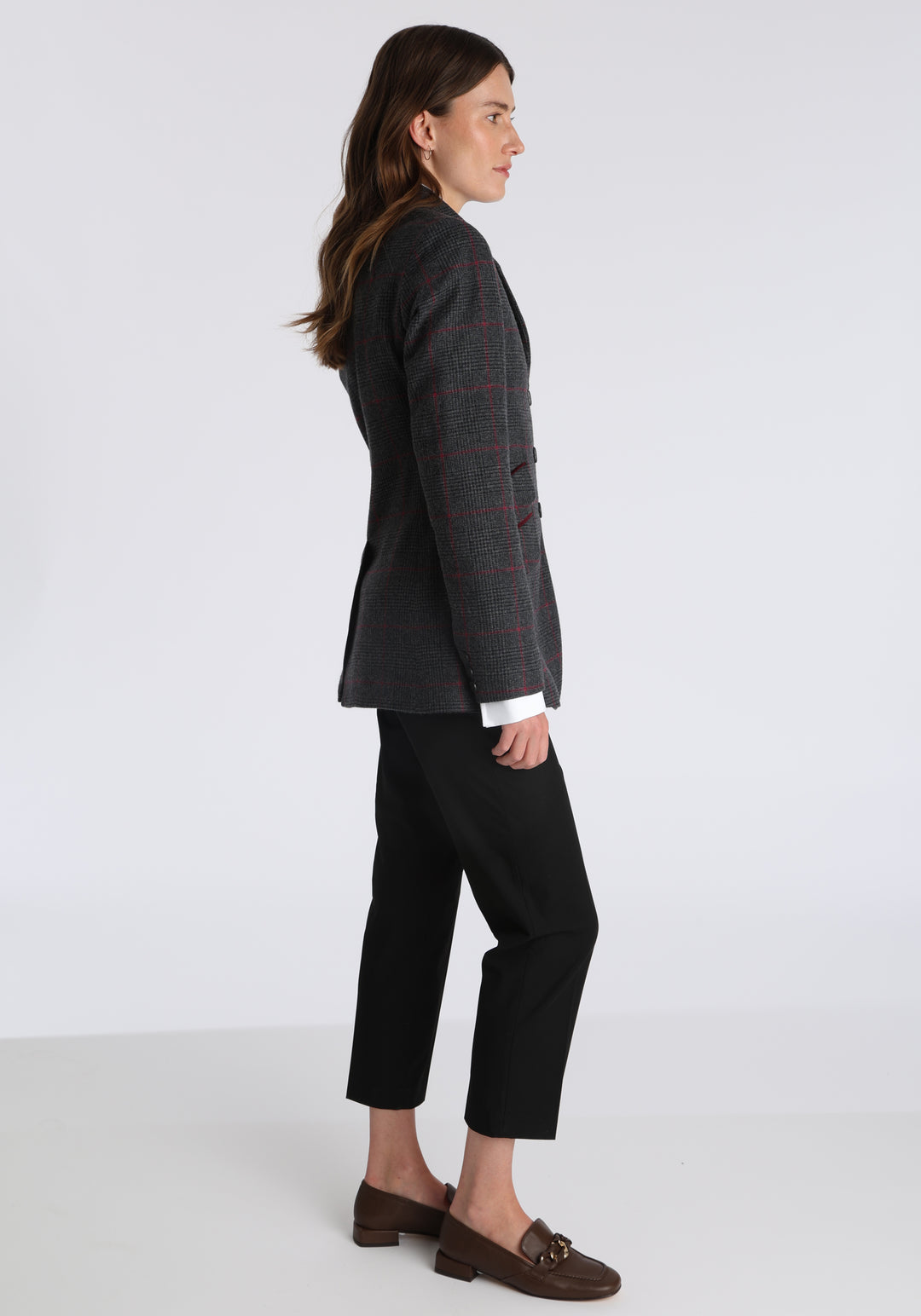 Model wearing the Cass jacket in grey a fuschia winterberry wool cashmere check with cotton velvet trim, a longline, relaxed boyfriend-style jacket with welt pockets, and buttoned collar tab inspired by equestrian tailoring.