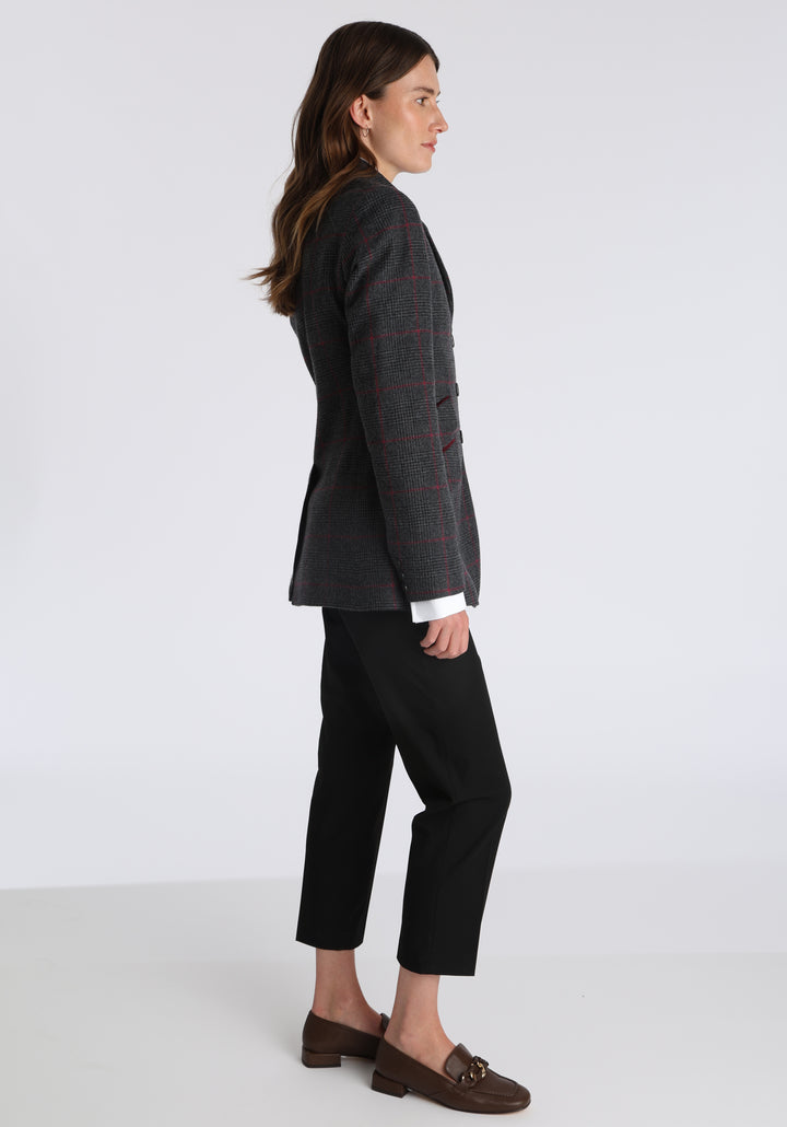 Model wearing the Cass jacket in grey a fuschia winterberry wool cashmere check with cotton velvet trim, a longline, relaxed boyfriend-style jacket with welt pockets, and buttoned collar tab inspired by equestrian tailoring.