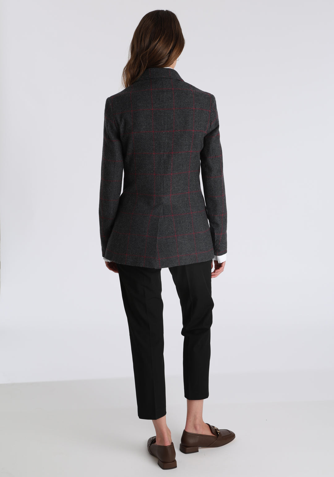 Model wearing the Cass jacket in grey a fuschia winterberry wool cashmere check with cotton velvet trim, a longline, relaxed boyfriend-style jacket with welt pockets, and buttoned collar tab inspired by equestrian tailoring.