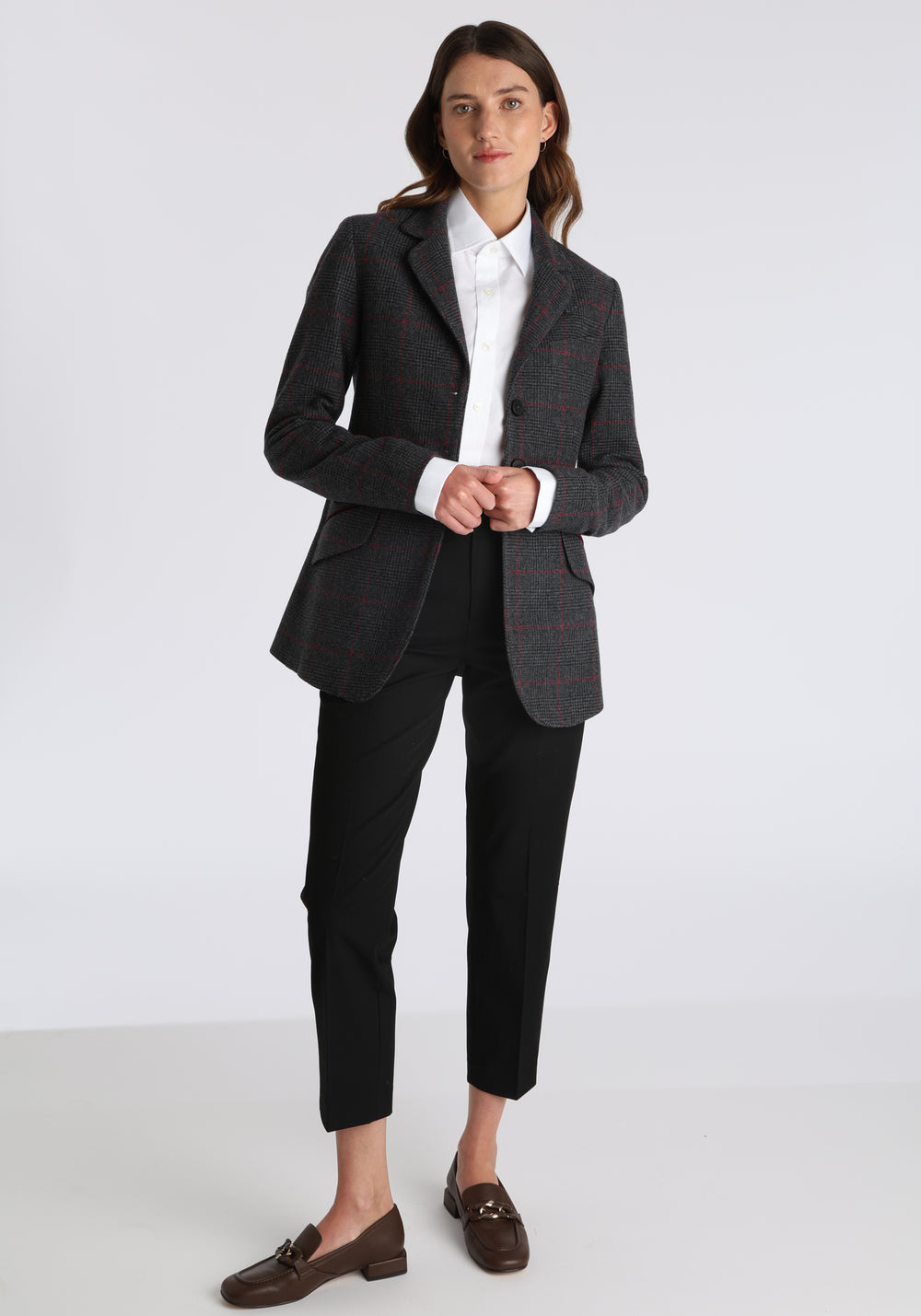 Model wearing the Cass jacket in grey a fuschia winterberry wool cashmere check with cotton velvet trim, a longline, relaxed boyfriend-style jacket with welt pockets, and buttoned collar tab inspired by equestrian tailoring.