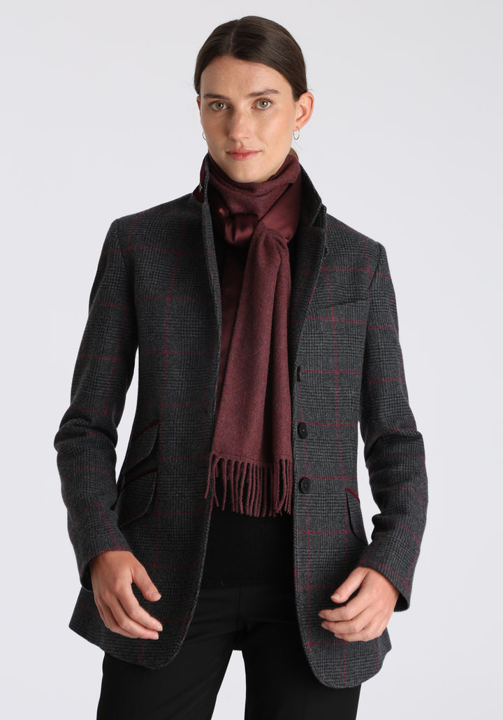 Model wearing the Cass jacket in grey a fuschia winterberry wool cashmere check with cotton velvet trim, a longline, relaxed boyfriend-style jacket with welt pockets, and buttoned collar tab inspired by equestrian tailoring.