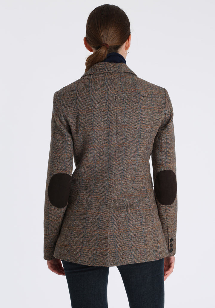 Model wearing the Cass jacket in clay check Harris Tweed with suede trim, a longline, relaxed boyfriend-style jacket with welt pockets, and buttoned collar tab inspired by equestrian tailoring.