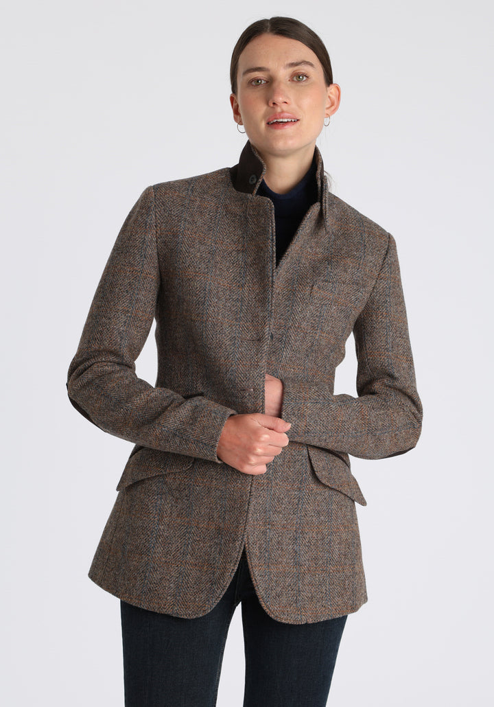 Model wearing the Cass jacket in clay check Harris Tweed with suede trim, a longline, relaxed boyfriend-style jacket with welt pockets, and buttoned collar tab inspired by equestrian tailoring.