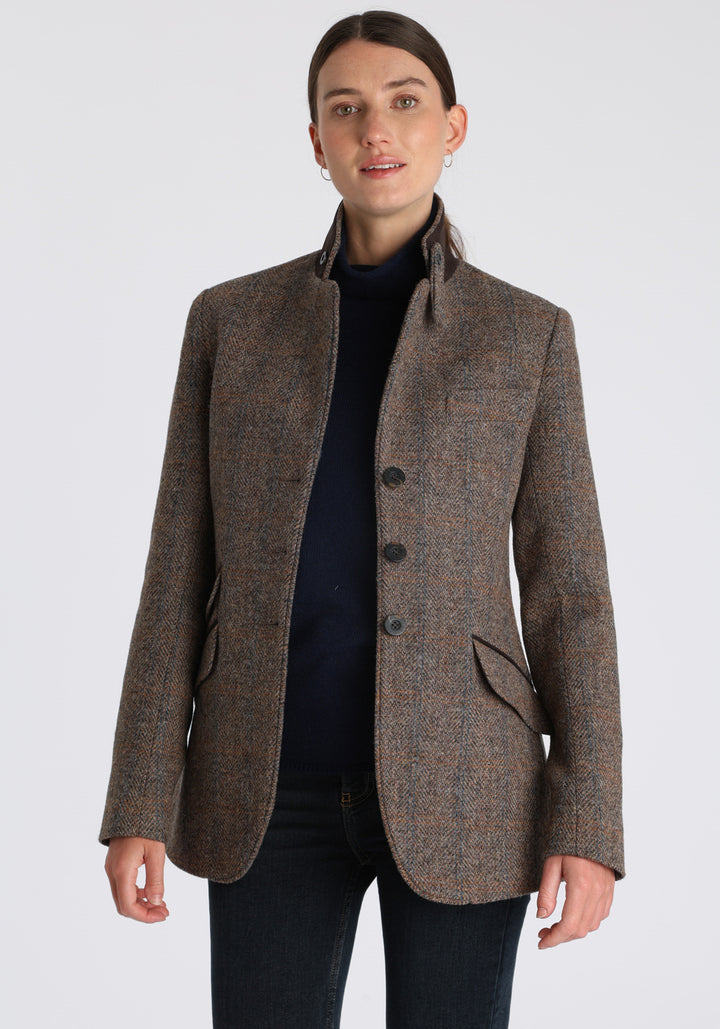 Model wearing the Cass jacket in clay check Harris Tweed with suede trim, a longline, relaxed boyfriend-style jacket with welt pockets, and buttoned collar tab inspired by equestrian tailoring.