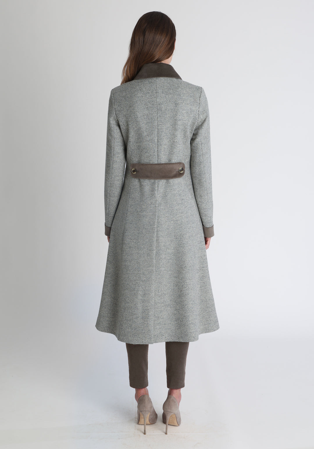 Model wearing the Contrast coat in slate blue and cream twill lambswool with cotton velvet detailing on the collar, cuffs, back belt, and pocket flaps, a longline occasion wear style with a timeless silhouette.
