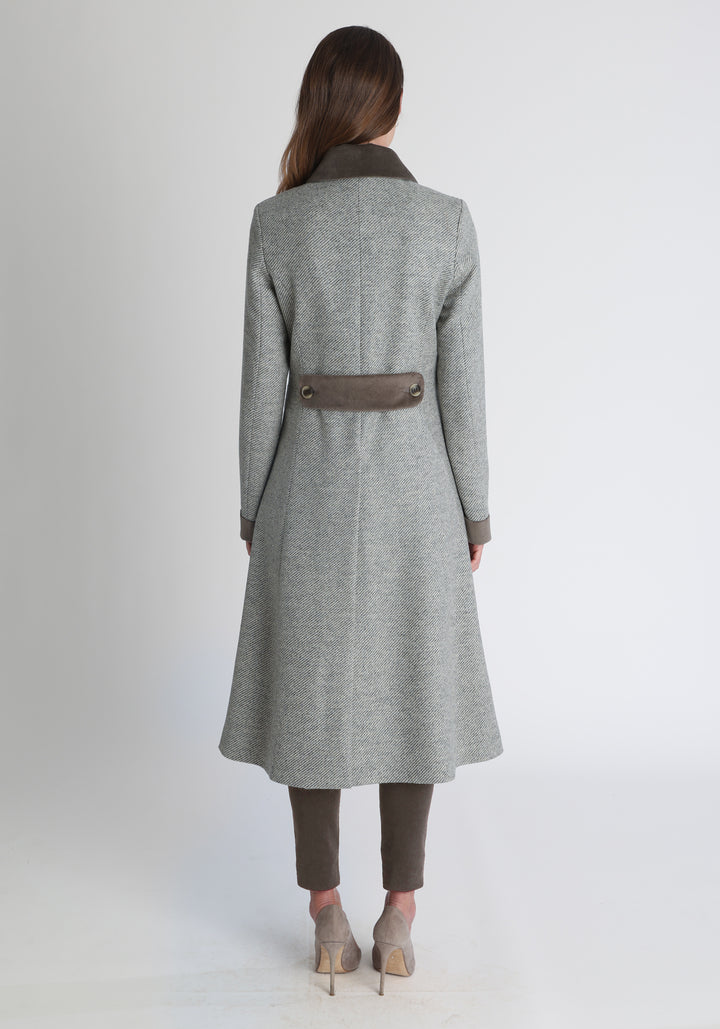 Model wearing the Contrast coat in slate blue and cream twill lambswool with cotton velvet detailing on the collar, cuffs, back belt, and pocket flaps, a longline occasion wear style with a timeless silhouette.