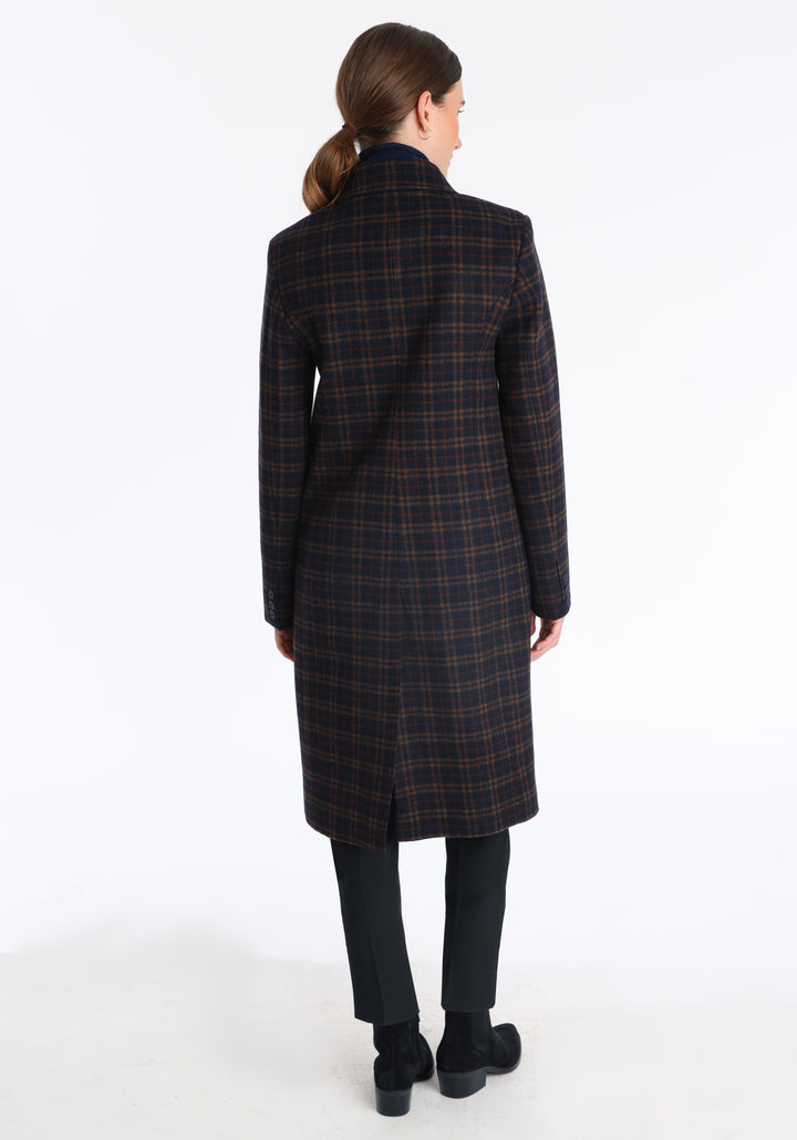 Model wearing the Cully coat in navy and rust check merino wool, a knee-length, double-breasted style with pointed lapels and a structured, straight-cut silhouette designed to flatter.