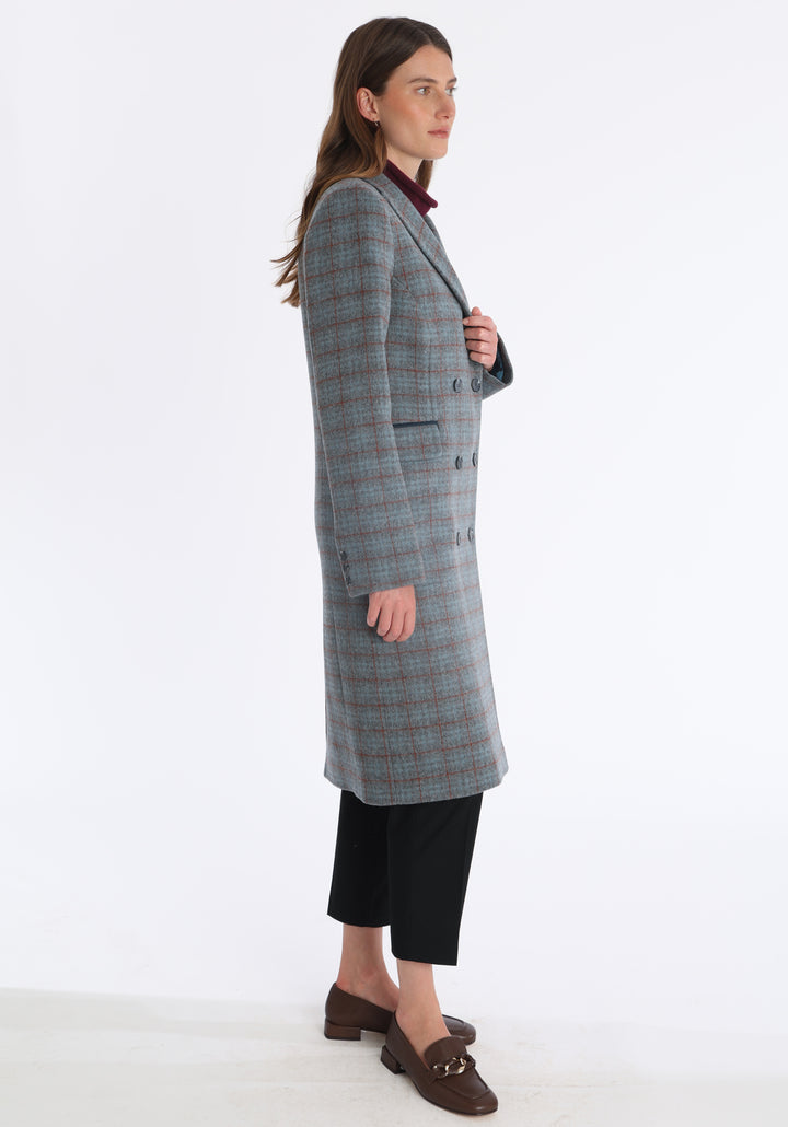 Model wearing the Cully coat in silver and rust check merino wool, a knee-length, double-breasted style with pointed lapels and a structured, straight-cut silhouette designed to flatter.