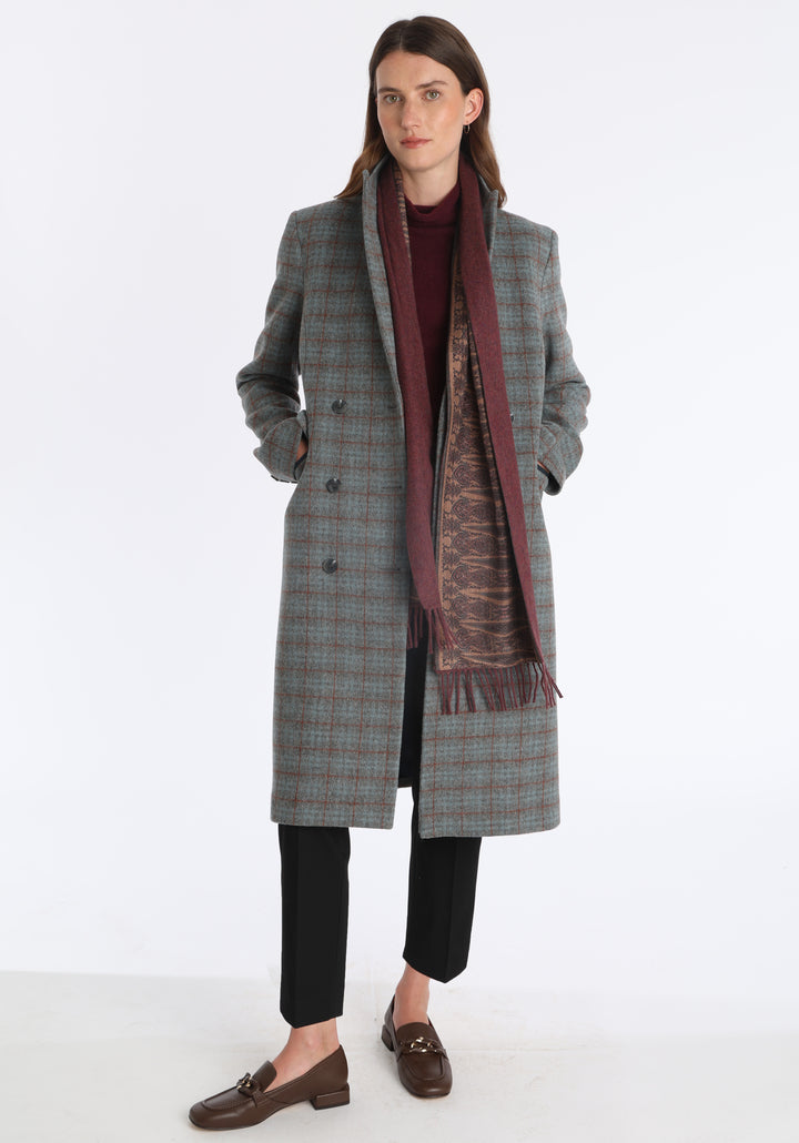 Model wearing the shiraz marl cashmere scarf backed with antique camel paisley printed silk, styled with the Cully coat in silver blue and rust check.