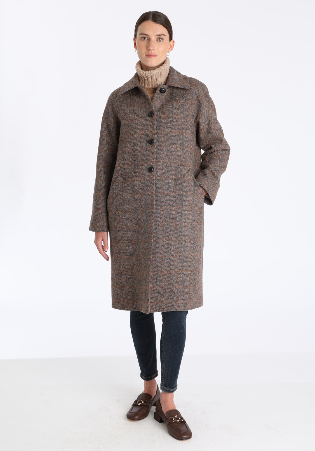 Model wearing the Dari coat in clay check Harris Tweed, a relaxed cocoon-shaped style with raglan sleeves, finished with chocolate suede under the collar.