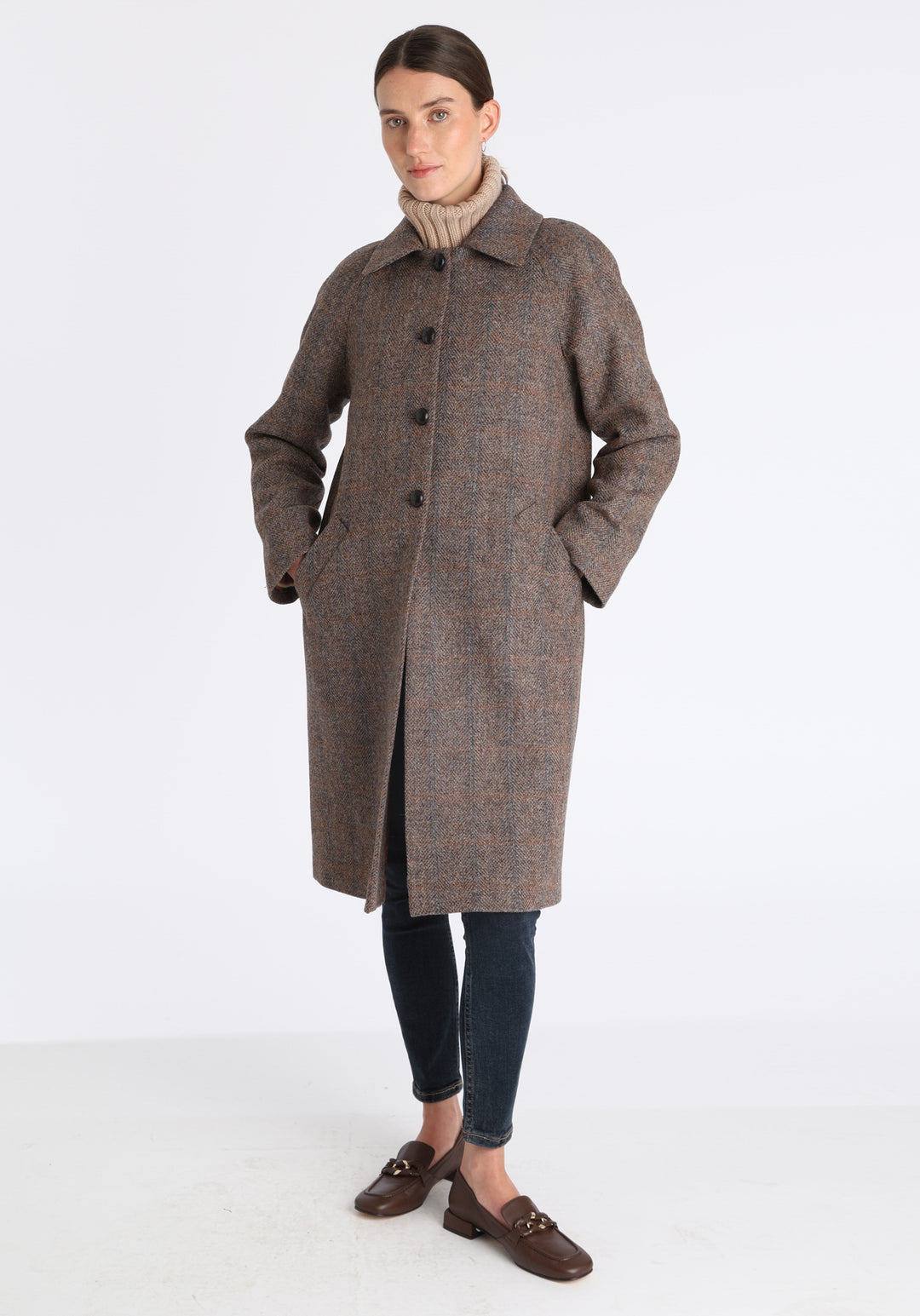 Model wearing the Dari coat in clay check Harris Tweed, a relaxed cocoon-shaped style with raglan sleeves, finished with chocolate suede under the collar.