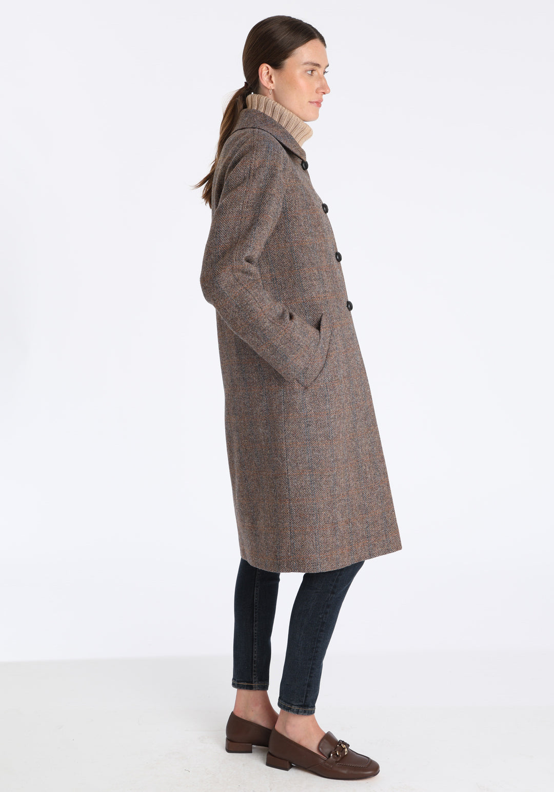 Model wearing the Dari coat in clay check Harris Tweed, a relaxed cocoon-shaped style with raglan sleeves, finished with chocolate suede under the collar.