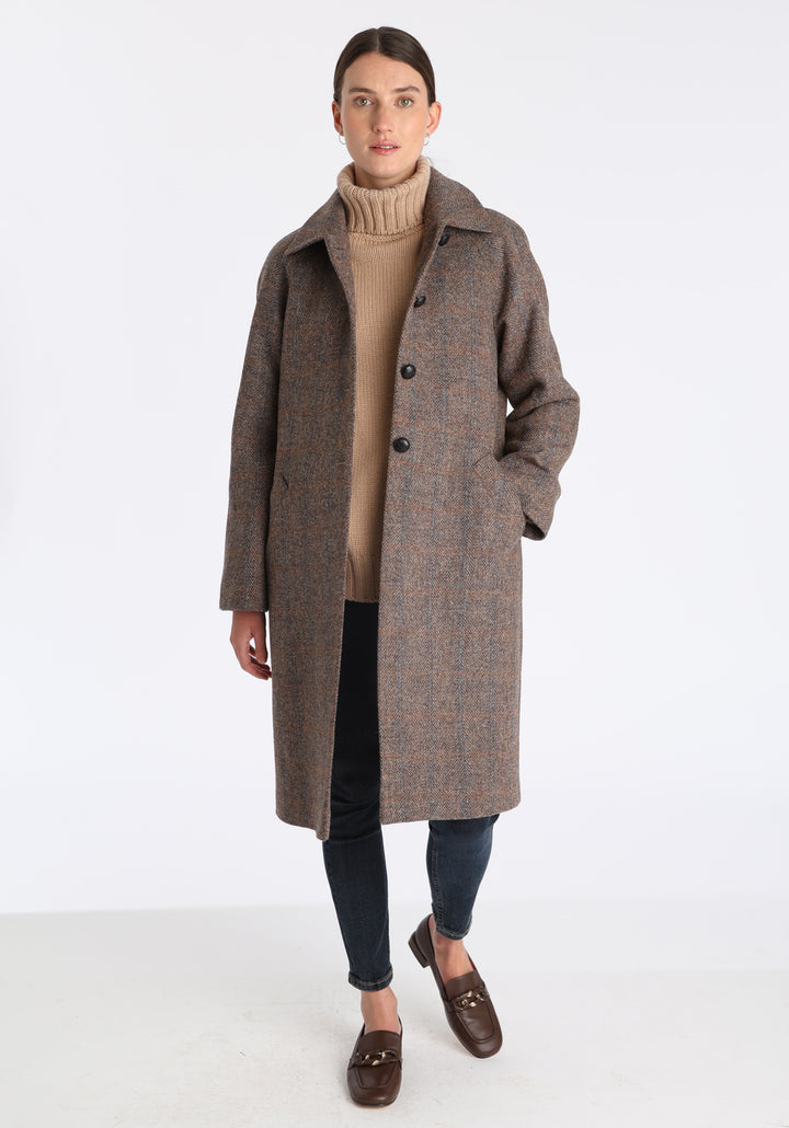 Model wearing the Dari coat in clay check Harris Tweed, a relaxed cocoon-shaped style with raglan sleeves, finished with chocolate suede under the collar.