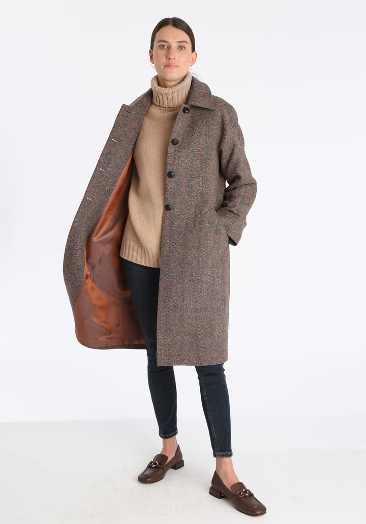 Model wearing the Dari coat in clay check Harris Tweed, a relaxed cocoon-shaped style with raglan sleeves, finished with chocolate suede under the collar.