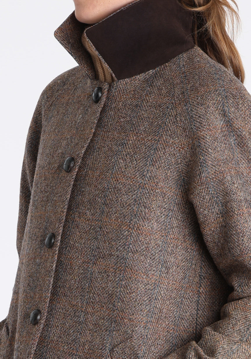 Model wearing the Dari coat in clay check Harris Tweed, a relaxed cocoon-shaped style with raglan sleeves, finished with chocolate suede under the collar.