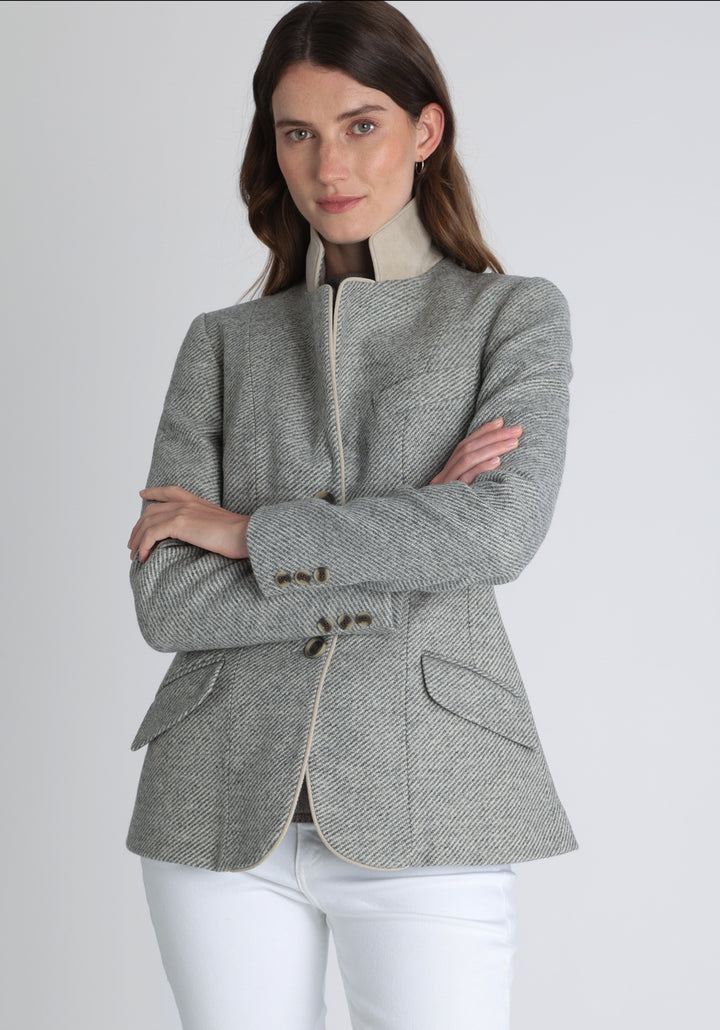 Model wearing the Hacking jacket slate blue and cream twill lambswool, a slim fit style with notched lapels, angled hip pockets, and a single back vent, inspired by traditional equestrian tailoring.