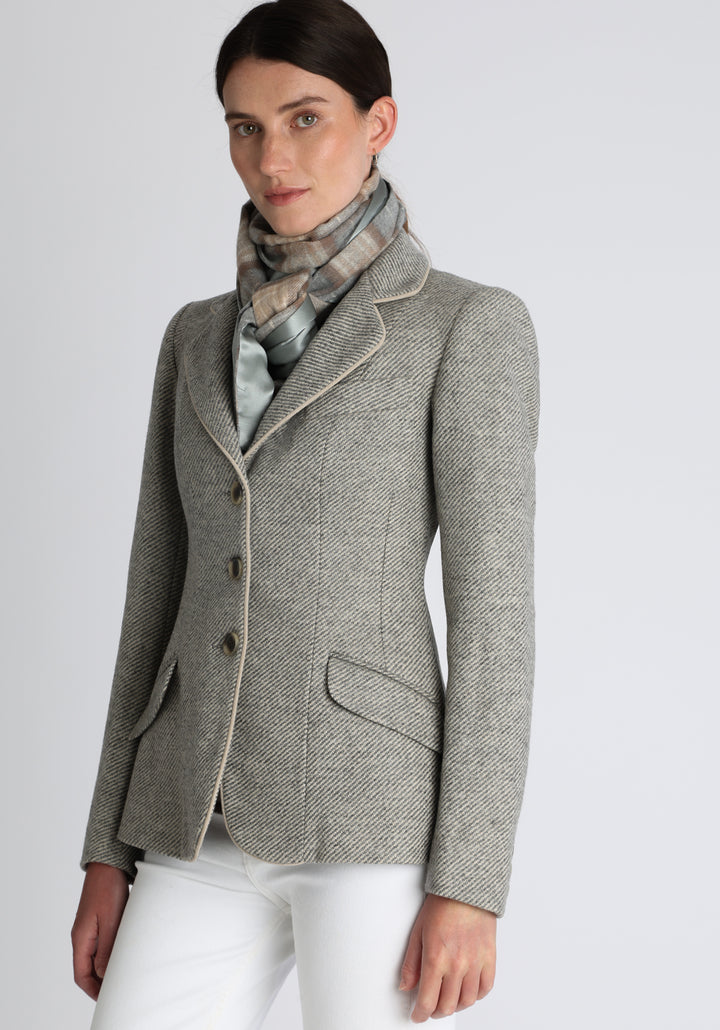 Model wearing the natural check cashmere scarf backed with silver blue silk, over the Hacking jacket in grey angle stripe.