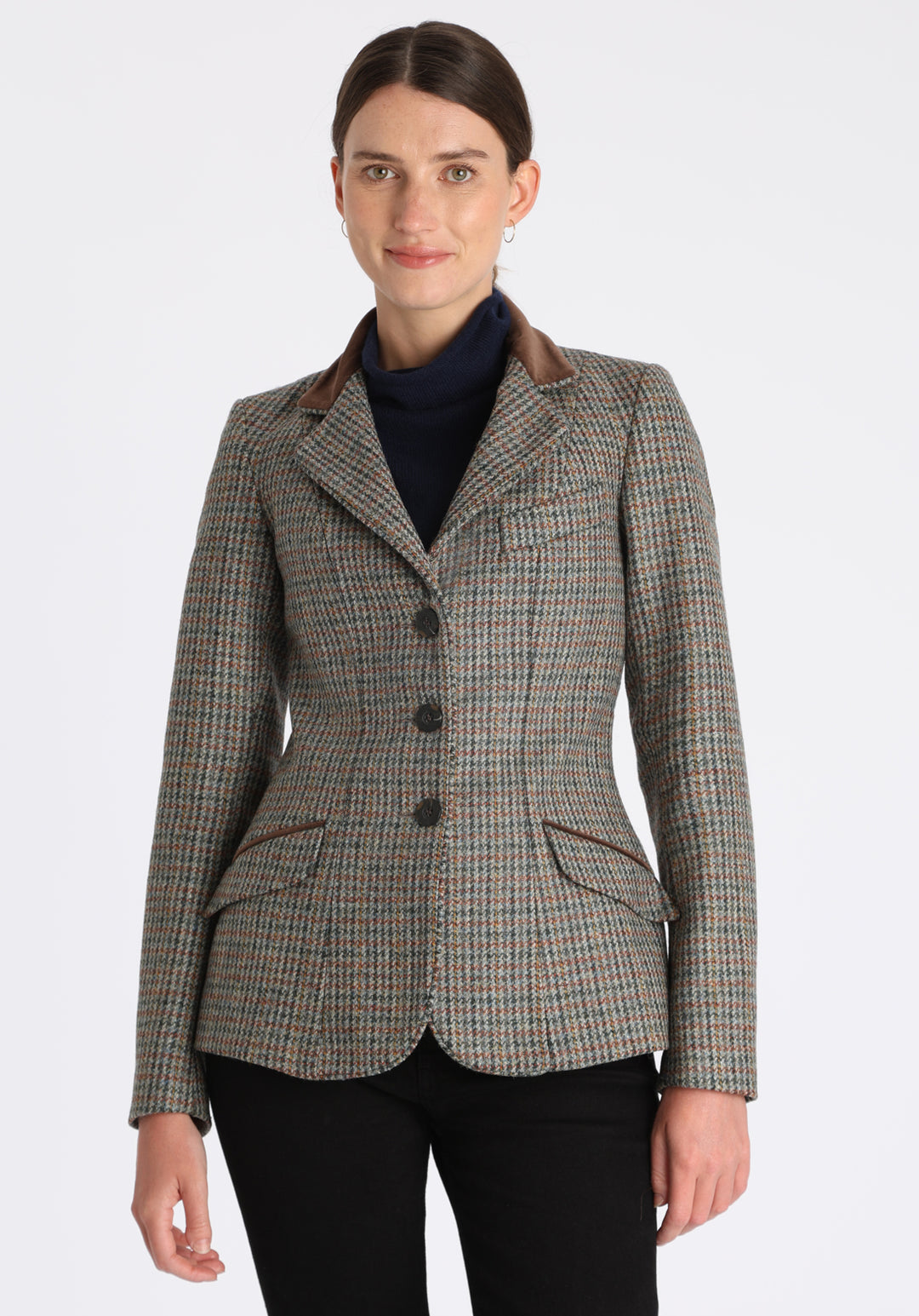 Model wearing the Hacking jacket in an autumnal cinder check wool, a slim fit style with notched lapels, angled hip pockets, and a single back vent, inspired by traditional equestrian tailoring.
