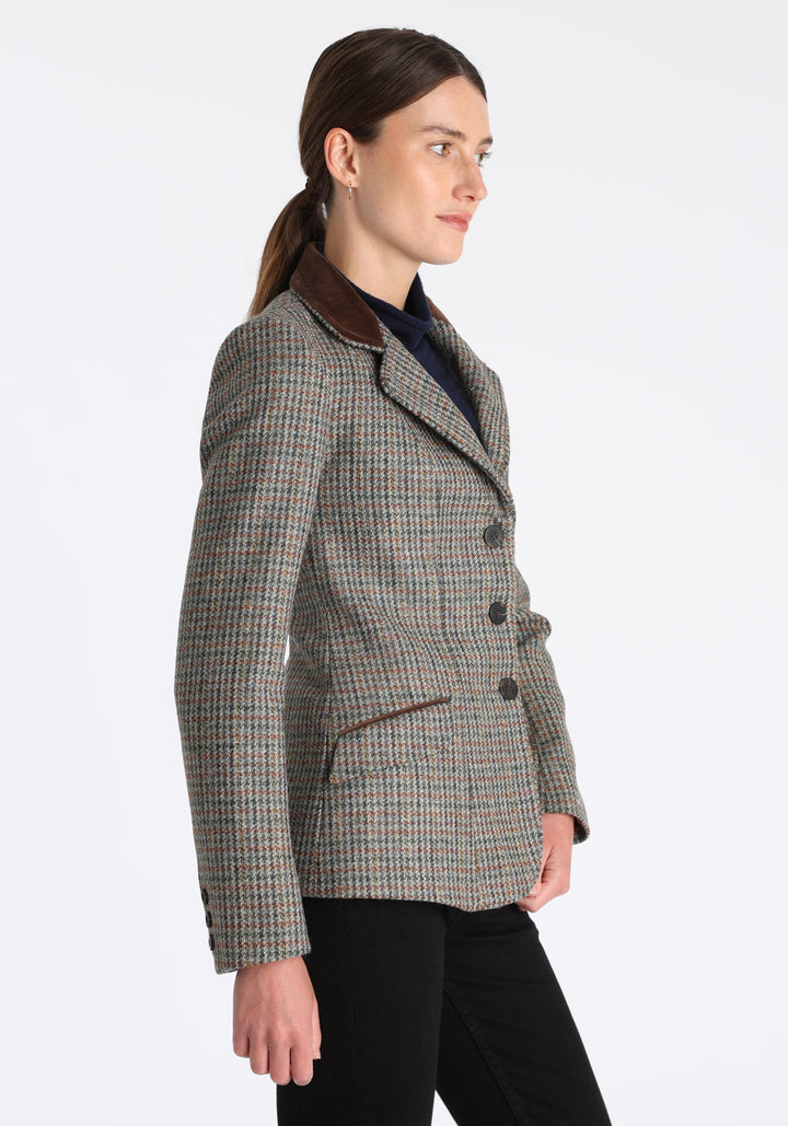 Model wearing the Hacking jacket in an autumnal cinder check wool, a slim fit style with notched lapels, angled hip pockets, and a single back vent, inspired by traditional equestrian tailoring.