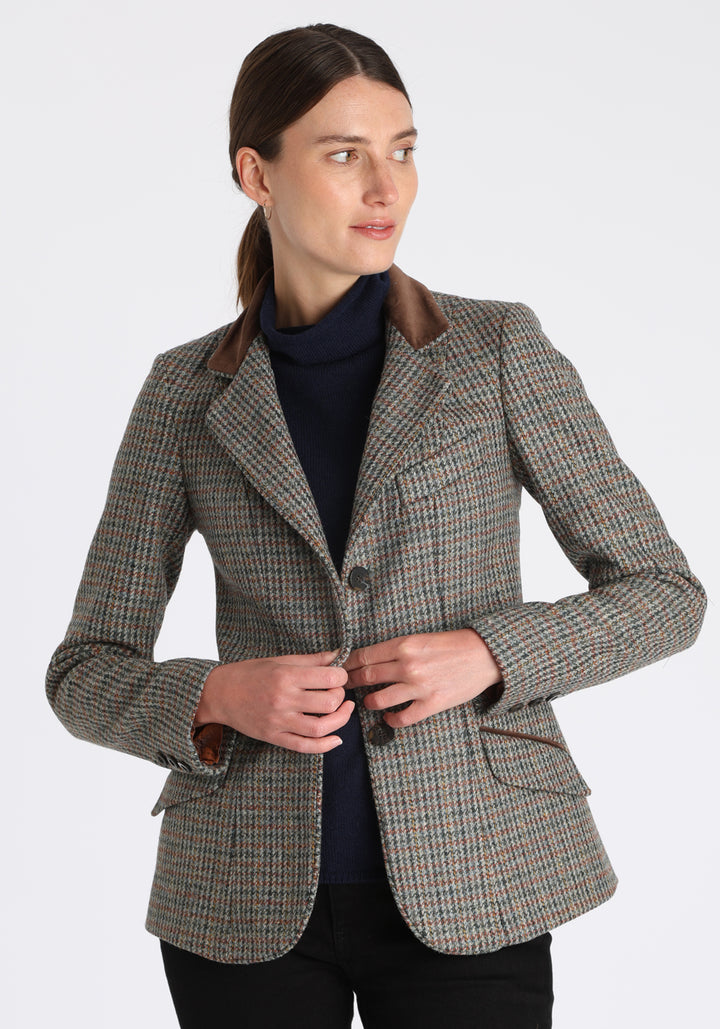 Model wearing the Hacking jacket in an autumnal cinder check wool, a slim fit style with notched lapels, angled hip pockets, and a single back vent, inspired by traditional equestrian tailoring.