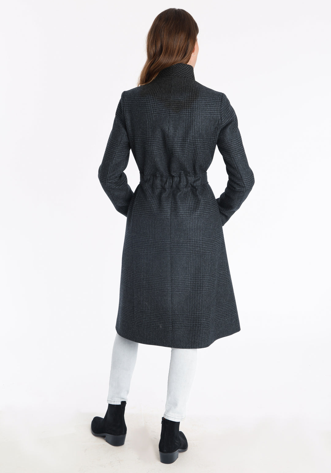 Model wearing the Hillsy coat in a black and charcoal grey Prince of Wales check, a wrap-style design with a standing collar, and tie belt, offering a softly tailored, elegant silhouette.