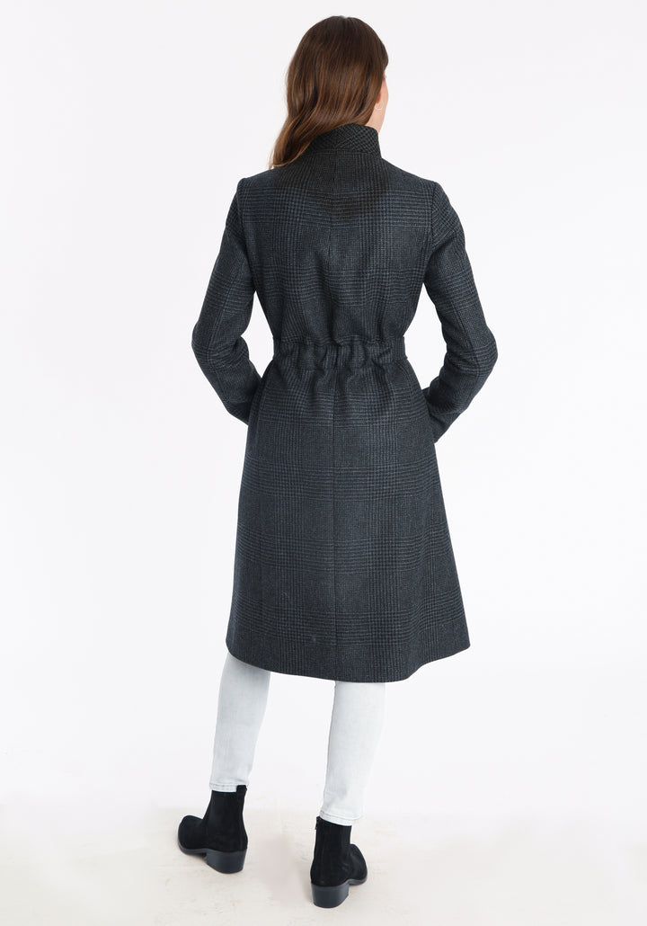 Model wearing the Hillsy coat in a black and charcoal grey Prince of Wales check, a wrap-style design with a standing collar, and tie belt, offering a softly tailored, elegant silhouette.