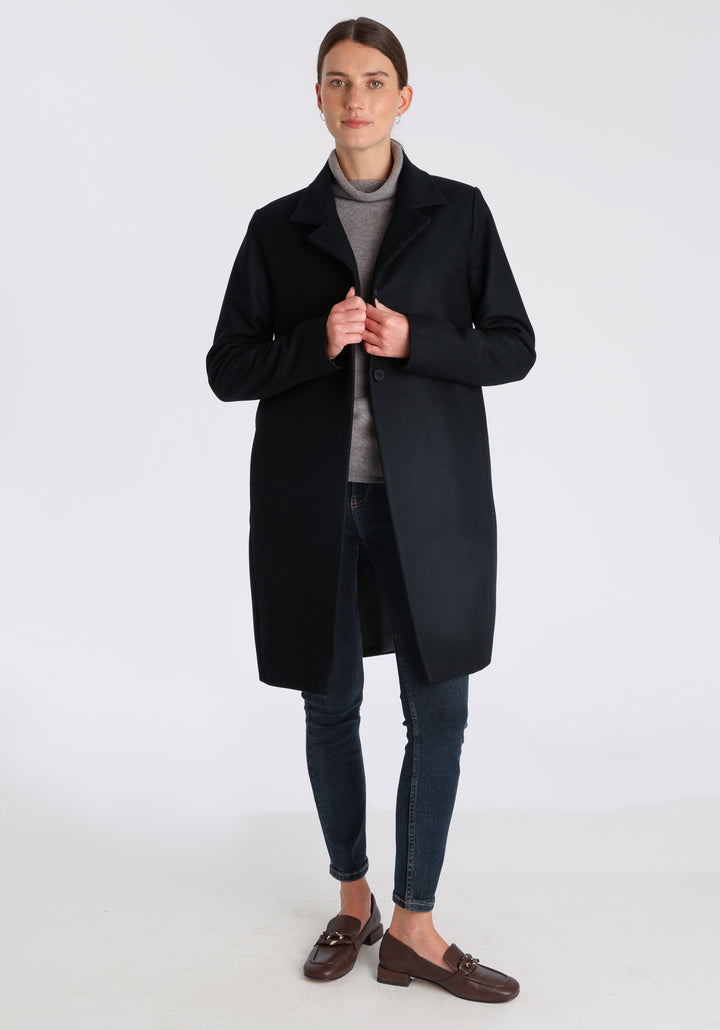 Model wearing the Jackson coat in black cashmere blend, a staple cocoon-shaped style with tailored shoulders and a clean, streamlined silhouette.