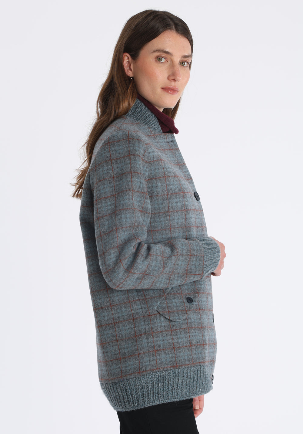 Model wearing the Jeffy jacket in silver blue and rust check merino wool, a baseball-inspired style with curved pocket flaps, front button fastenings, and ribbed knit trim, cut in a streamlined silhouette.