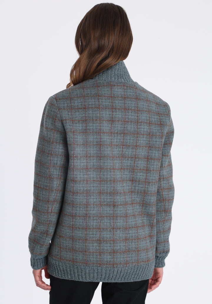 Model wearing the Jeffy jacket in silver blue and rust check merino wool, a baseball-inspired style with curved pocket flaps, front button fastenings, and ribbed knit trim, cut in a streamlined silhouette.